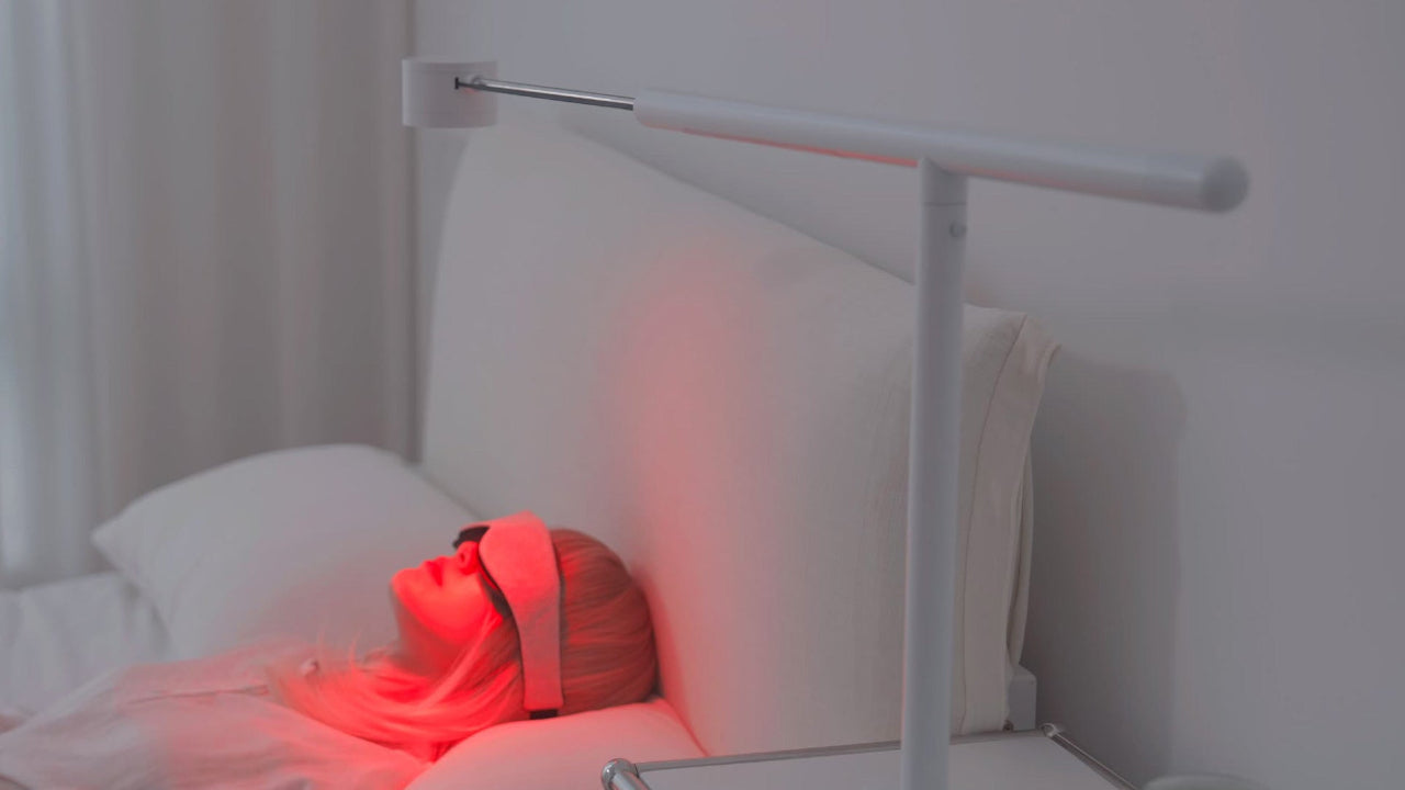 Forecee Beauty Lamp in beauty mode providing relaxing red-light therapy to a person lying in bed with an eye mask.