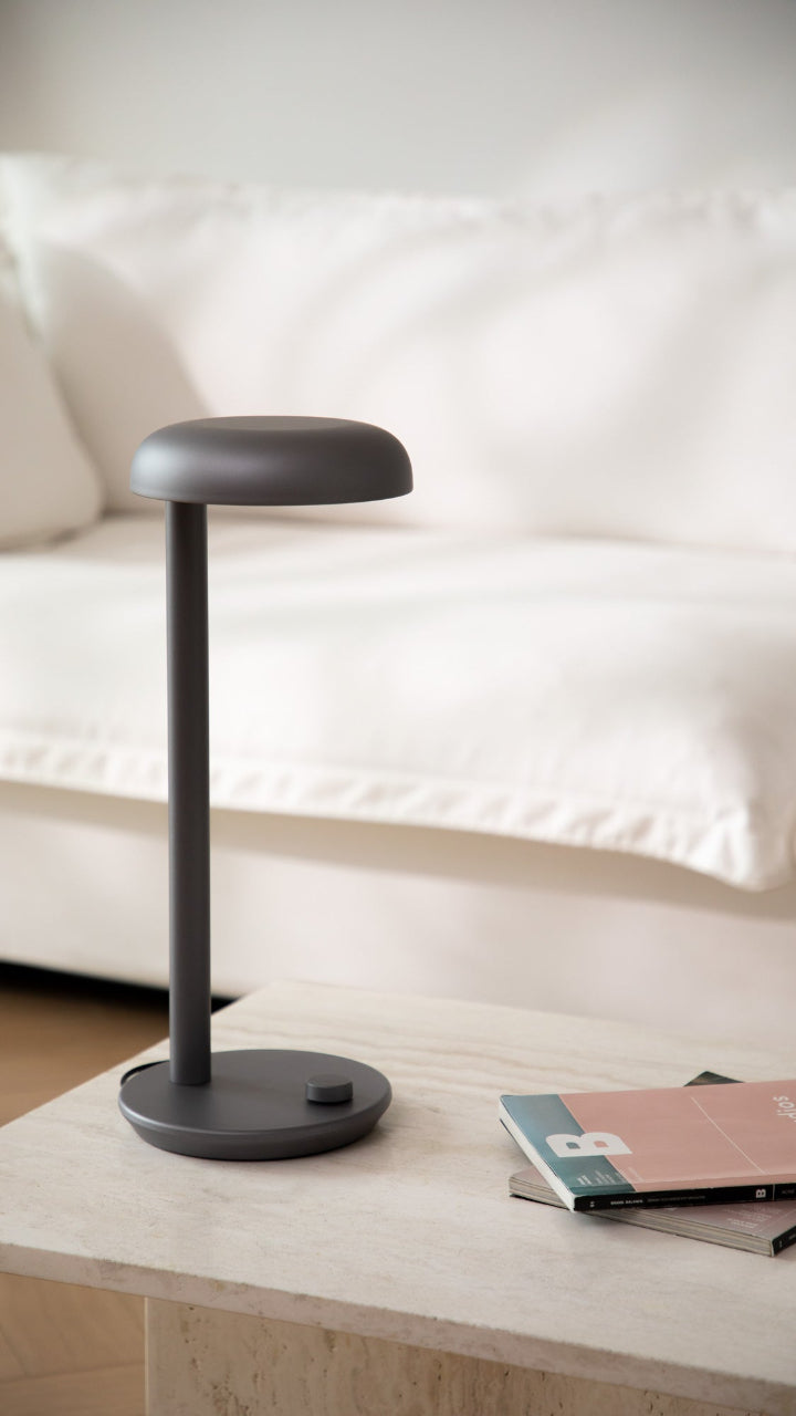Minimalist gray Forecee Desk Lamp on a wooden table, complementing light-toned interiors.