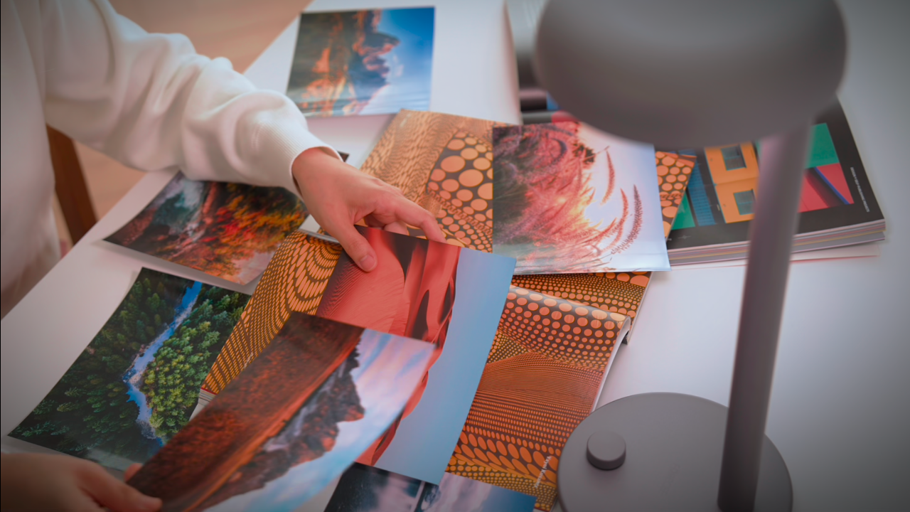 Person holding a colorful photo under Forecee Desk Lamp, showing accurate color rendering and full-spectrum illumination.