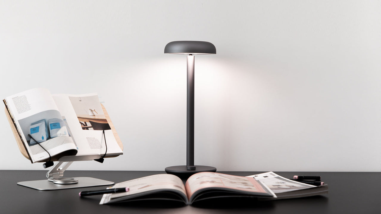 Forecee Desk Lamp lighting an open book on a white desk, showcasing wide, even illumination.