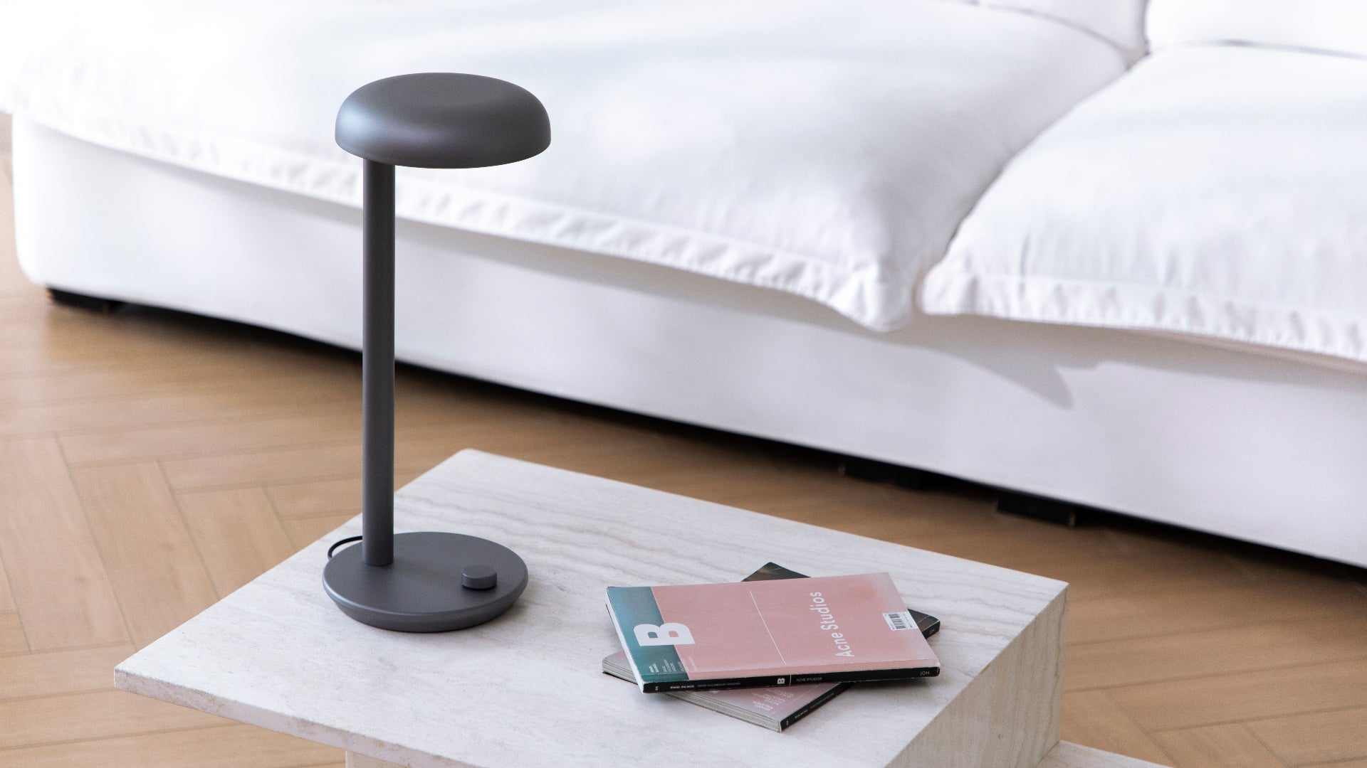 Grey Forecee Desk Lamp placed on a minimalist white shelf, fitting seamlessly into modern home decor.