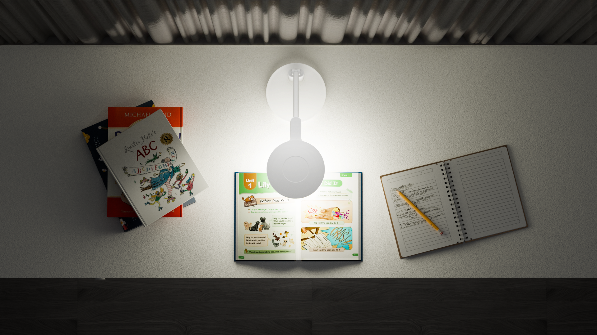 Same open book, notebook, and study materials on a white table. Comparison photo showing a regular desk lamp with uneven lighting — bright hotspot near lamp and shadows on far side of desk.