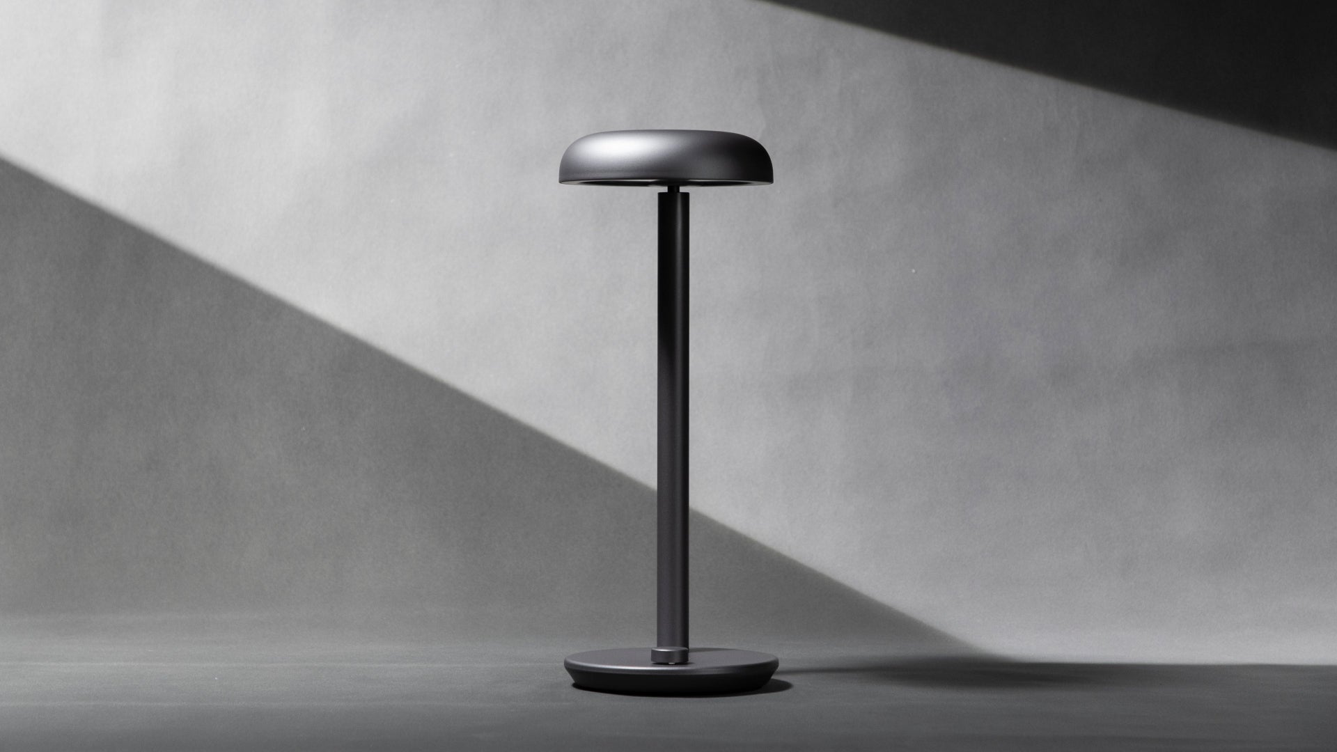 Modern Forecee desk lamp on a light gray background, front view
